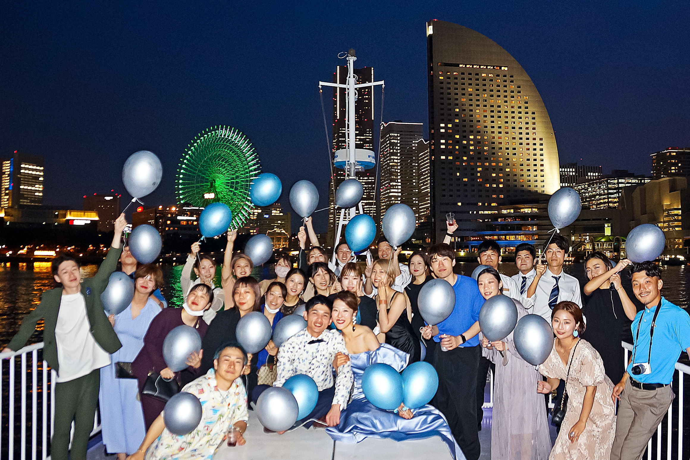 横浜の夜景をバックにデッキで集合写真
