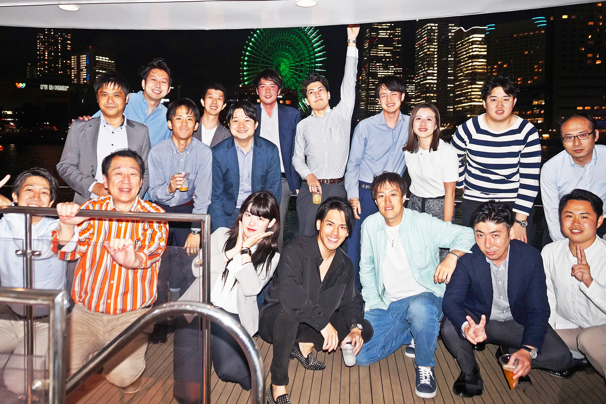 横浜の夜景をバックにデッキで集合写真