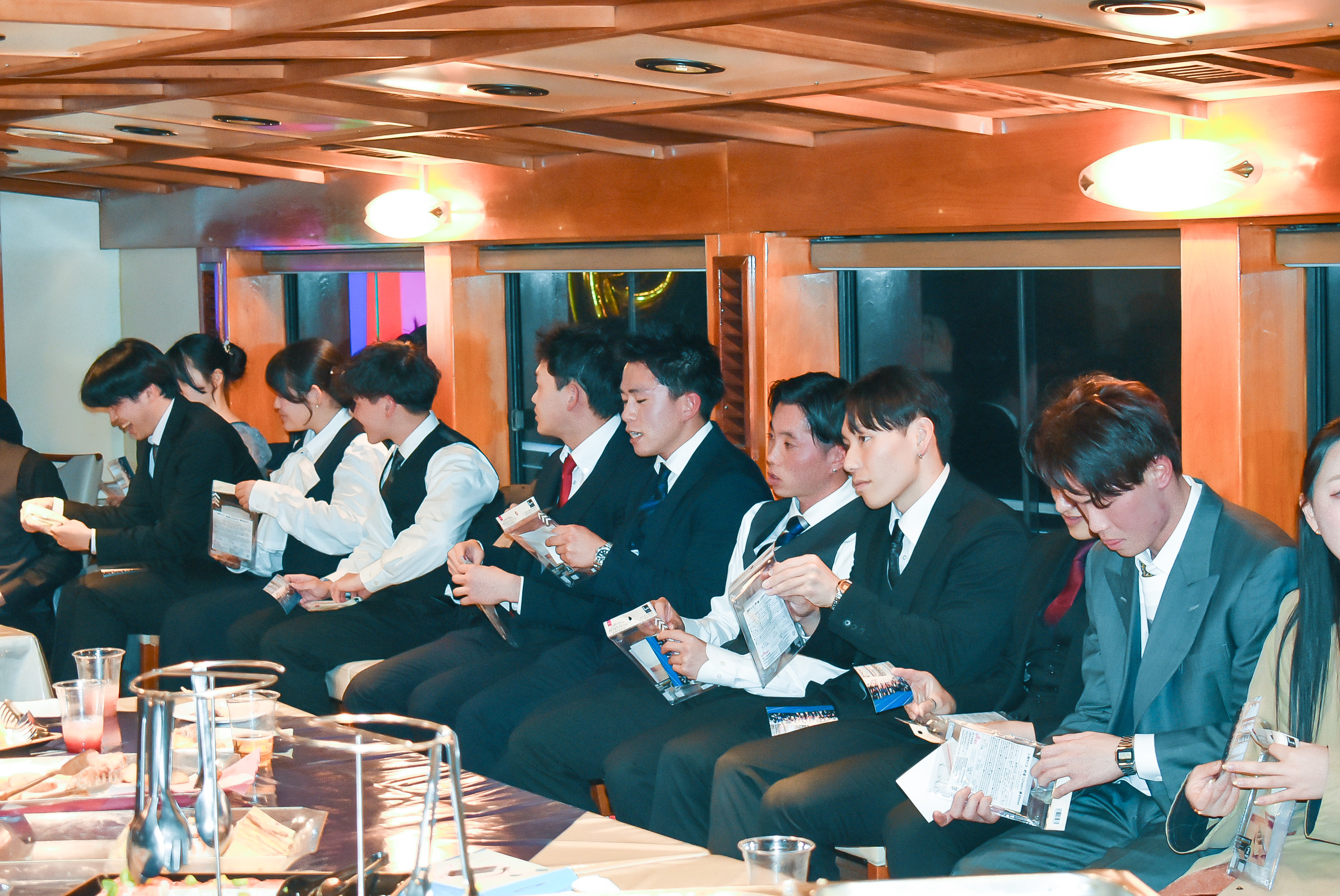 フォトフレームに入れられた集合写真を受け取る参加者