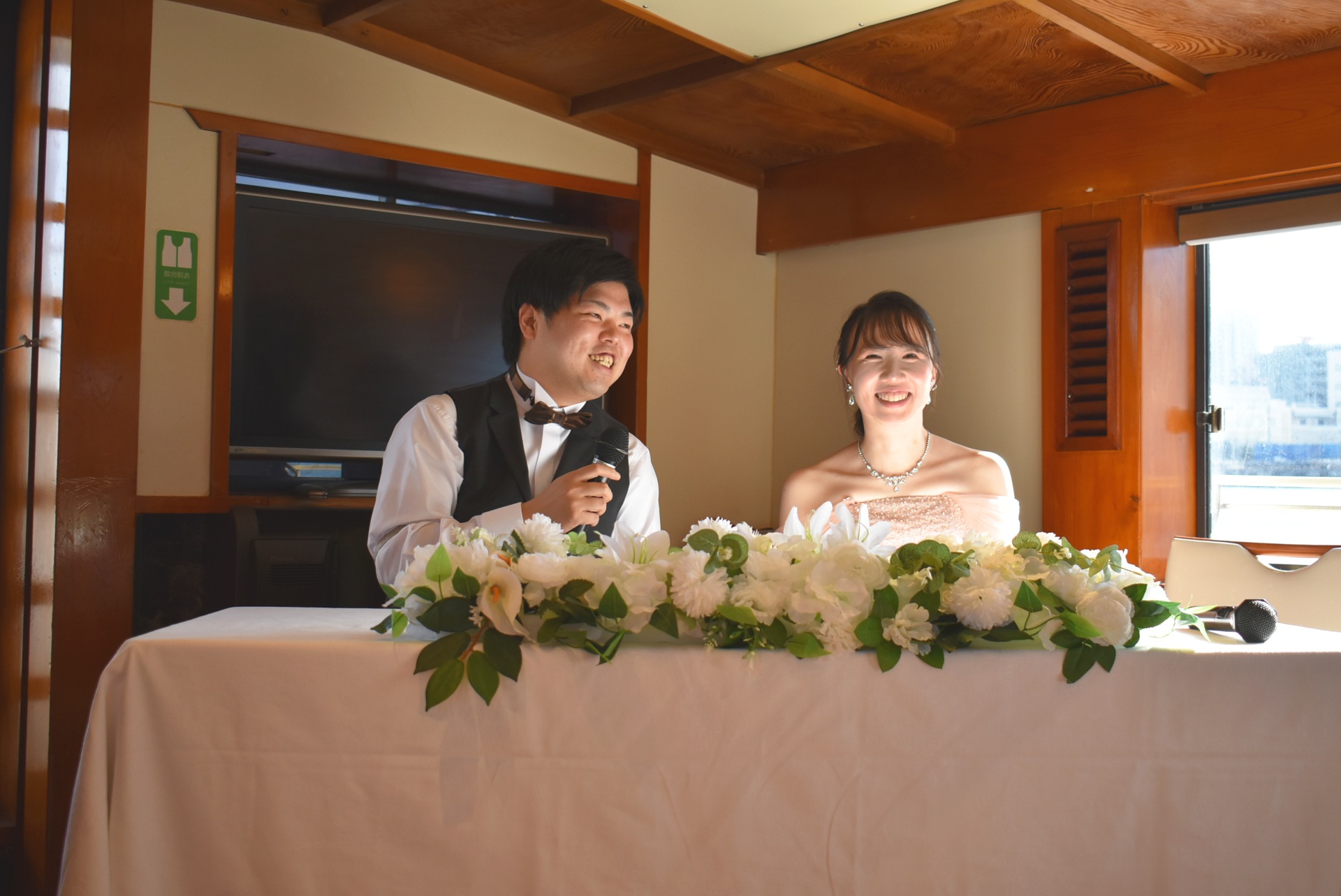 オリエンタルノア号の高砂席でほほ笑む新郎新婦